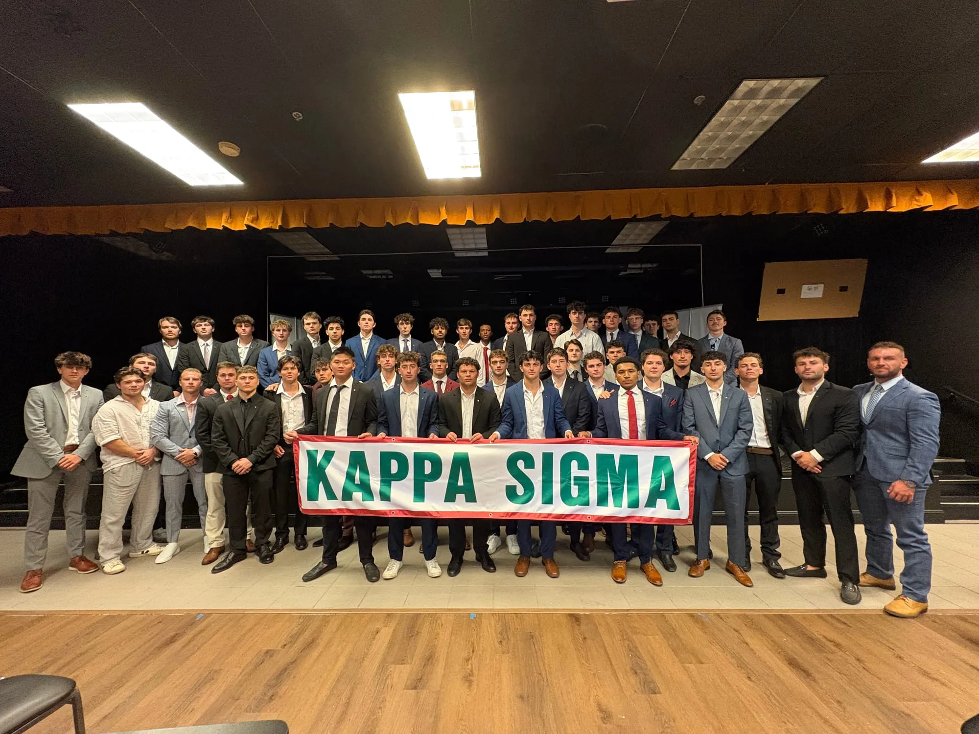 Pi-Theta brothers gathered behind the Kappa Sigma banner